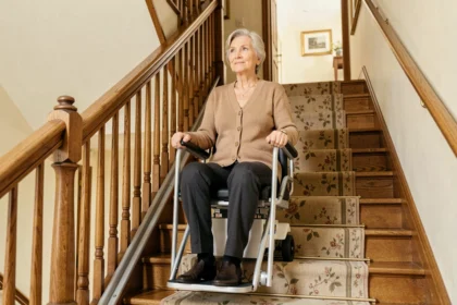 Femme senior utilisant un ascenseur portable sans installation sur un escalier intérieur en bois
